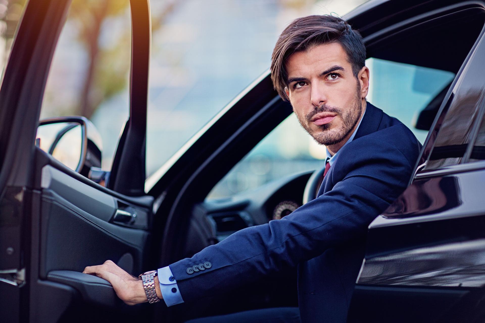 Businessman is entering/exiting his car